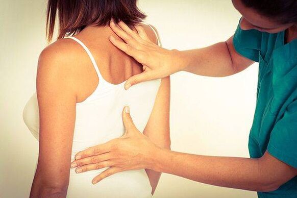 lekarz bada plecy z osteochondrozą klatki piersiowej